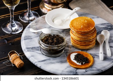 Black Caviar, Mini Pancakes and Sour Cream Holiday Party Appetizer on dark background