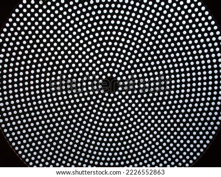 A black ceiling with a circular pattern of white dots