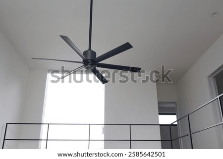 Black ceiling fan installed in white ceiling.