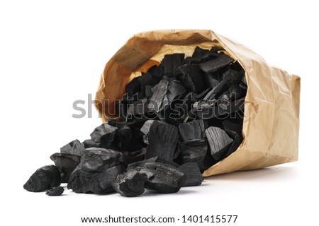 Black charcoal in a paper bag. Charcoal for igniting fire in a grill.