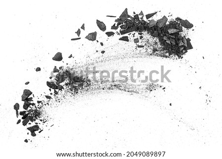 Black charcoal particles on a white background, top view. Activated charcoal powder for facial mask.