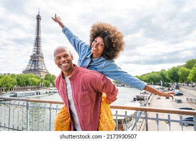 Black cheerful happy couple in love visiting Paris city centre and Eiffel Tower - African american tourists travelling in Europe and dating outdoors - Powered by Shutterstock