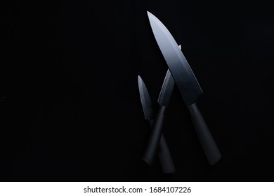 A Black Chef Knife Set On Black Background.