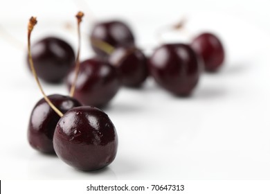 Black Cherries On White Background. Shallow DOF