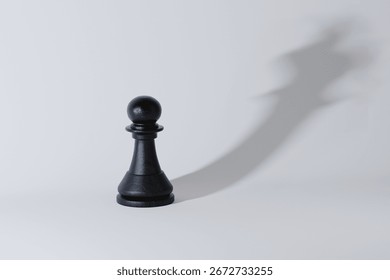 Black chess pawn casting a shadow of a crown, symbolizing ambition, potential, leadership, and transformation from ordinary to extraordinary with vision. Strategy leader, creative idea. King, concept