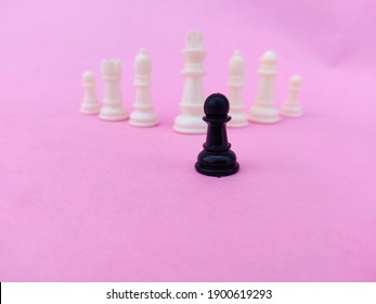 Black Chess Pawn Facing Mighty White Chess Pieces. Small Vs Big Business Competition Concept. Pink Background