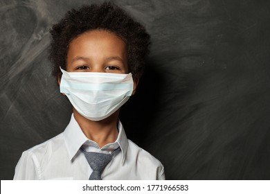 Black Child Boy In Medical Protective Face Mask On Blackboard Background