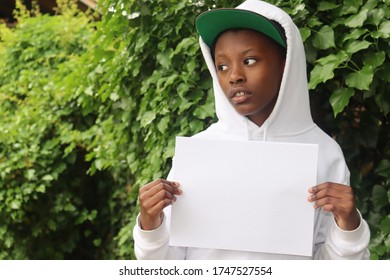 Black Child Holding Blank White Paper Sign Looking To Side 