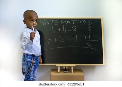 A Black Child Writing On A Blackboard