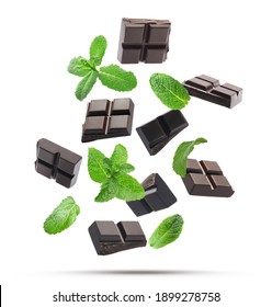 Black Chocolate Pieces And Mint Falling On White Background