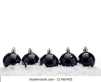 Black christmas balls with snow isolated on white background