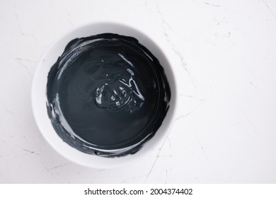 Black Clay Texture. Mud Mask For Face And Body In A Bowl. Natural Spa Treatment. Black And White Stylish Background. Cosmetology Skin Treatment