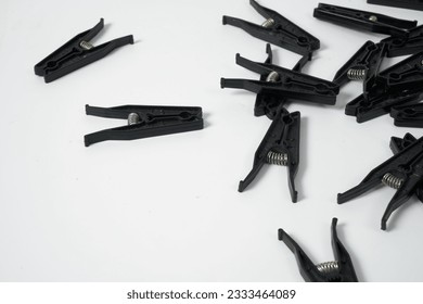 Black clothes pegs on a white background 