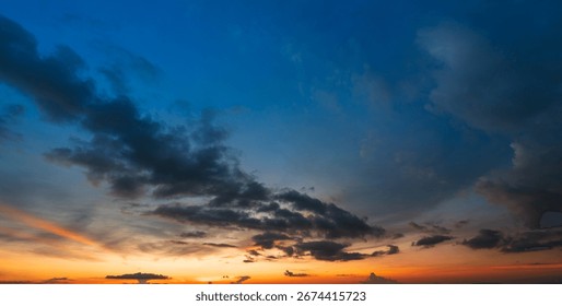 black cloud on sky gradient from blue to orange in sunset time