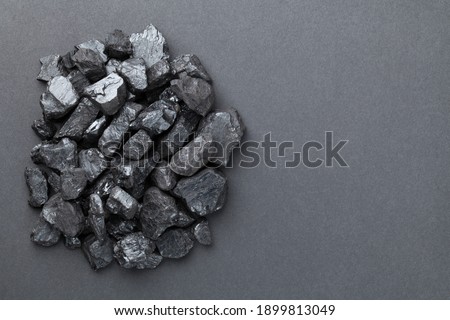 Black coal pile over graphite background. Copy space. Top view