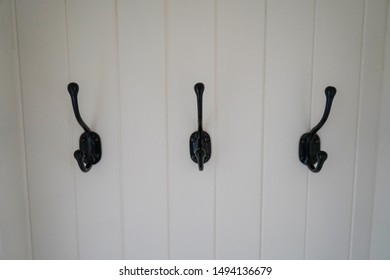 Black Coat Hooks On A White Wall