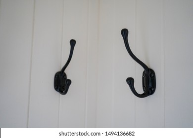 Black Coat Hooks On A White Wall