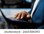 Black coder focused on programming with laptop at a digital workstation, writing binary code on terminal window for automation. Professional tech career in data science. Close up.