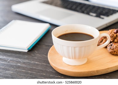 black coffee and cookies with laptop and note book on table - Shutterstock ID 525860020