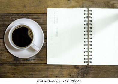 Black Coffee And Notbook On Wooden Floor