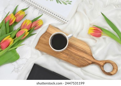 Black coffee on a wooden tray decorated with yellow and red tulips, top view. Romantic. - Powered by Shutterstock
