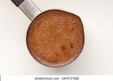 Black Coffee In Turkish Coffee Pot, Top View On White Table