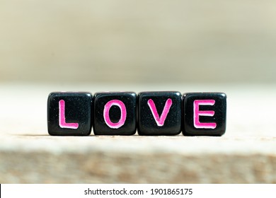 Black Color Block With Word Love On Wood Background