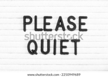 Black color letter in word please quiet on white felt board background