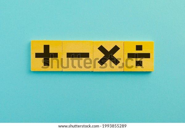 Black\
color of mathematical operations or Plus, minus, multiply, divide\
symbols on wooden cube over blue sky background use for\
mathematic,education,background,school\
concept.