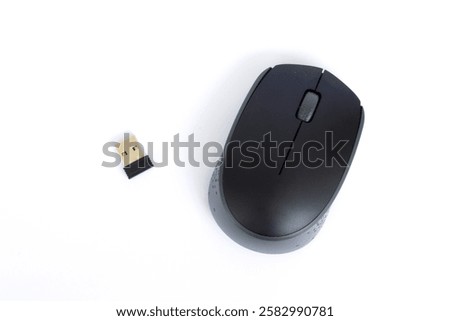 A black colored wireless computer mouse and its dongle on white