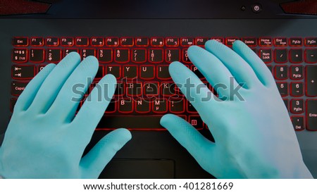 Black computer keyboard and hands in blue rubber gloves