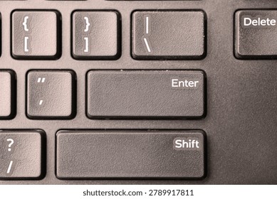 Black Computer Keyboard Macro Shot Highlighting Enter Key with Soft Blurred Backgrounds Top View