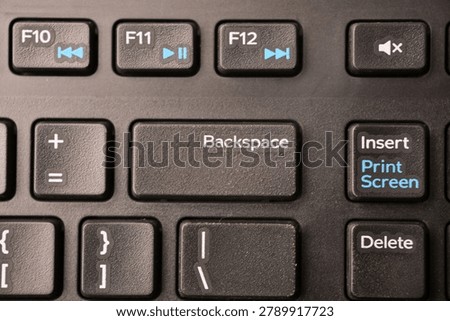 Black Computer Keyboard Macro Shot Highlighting Backspace Key with Soft Blurred Backgrounds Top View