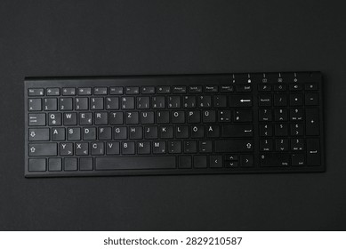 Black computer keyboard on a colored background
