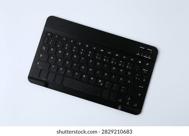 Black computer keyboard on a colored background
