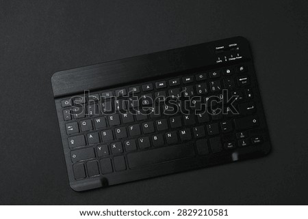 Black computer keyboard on a colored background
