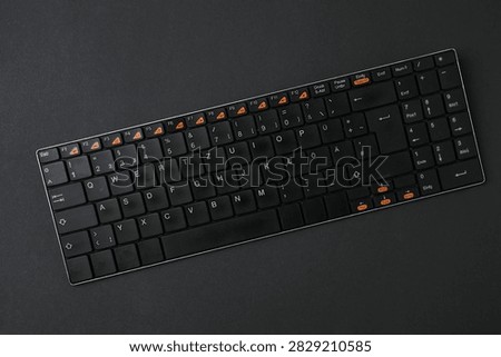 Black computer keyboard on a colored background
