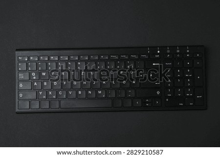 Black computer keyboard on a colored background

