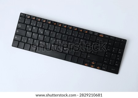Black computer keyboard on a colored background
