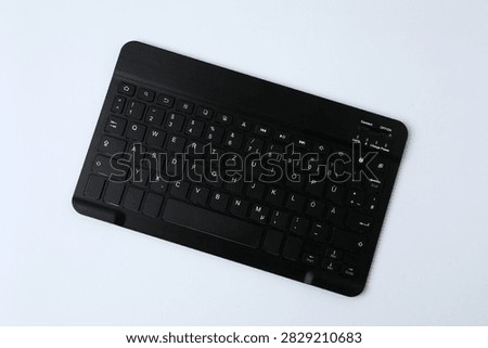 Black computer keyboard on a colored background
