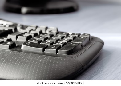 Black Computer Keyboard On A Light Gray Table. A Closeup Of A Used Office Keyboard. Eye Level Shooting. Selective Focus.