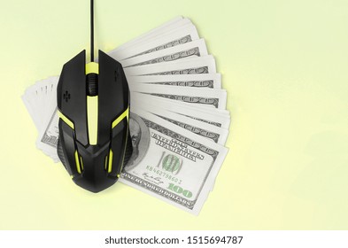 Black computer mouse on many hundred dollar bills