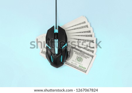 Black computer mouse on many hundred dollar bills