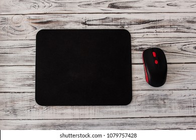 Black Computer Mousepad With A Mouse On A White Wooden Background