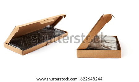 Black computer querty keyboard packed into cardboard box isolated over white background