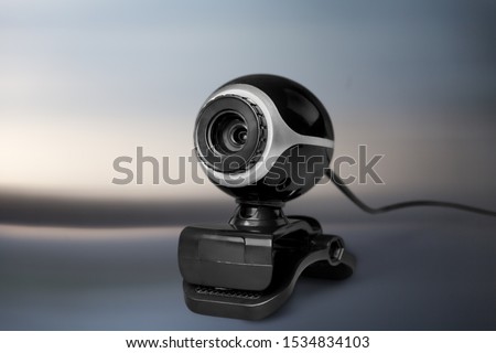 Black computer webcam staying on abstract background