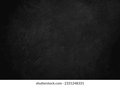 Black concrete background texture with vignetting.