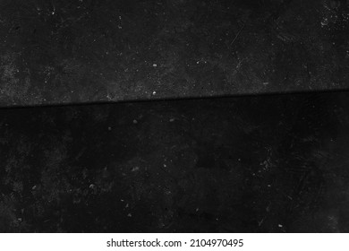 Black concrete wall. Grunge background. Dark wallpaper. Blackboard for text