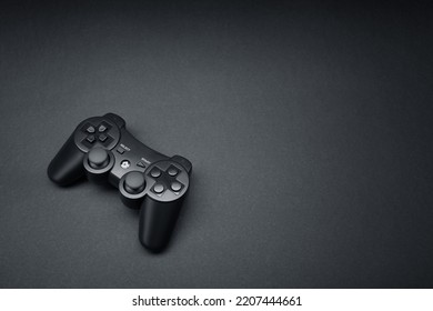 Black console video game joystick controller gamepad isolated on the dark solid black fond background - Shutterstock ID 2207444661