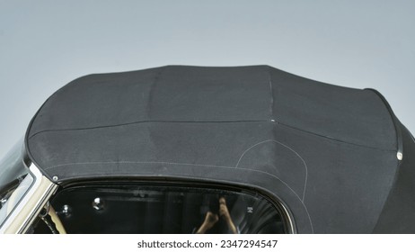 Black convertible top on a car from the drivers side